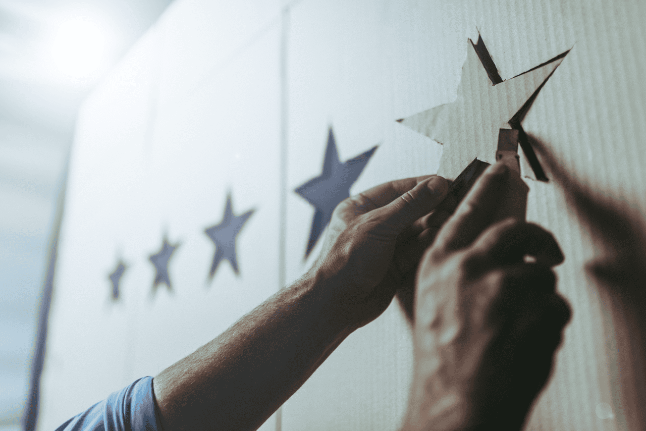 Hands drawing five stars on a board